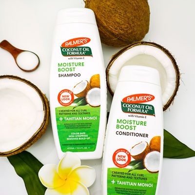 Palmer's Coconut Oil Formula Moisture Boost Shampoo and Conditioner for healthy a healthy hair routine on a table with coconuts
