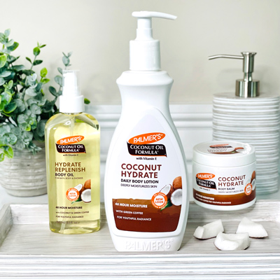 Palmer's Coconut Oil Formula with green coffee extract for skin on bathroom counter with coconut pieces 