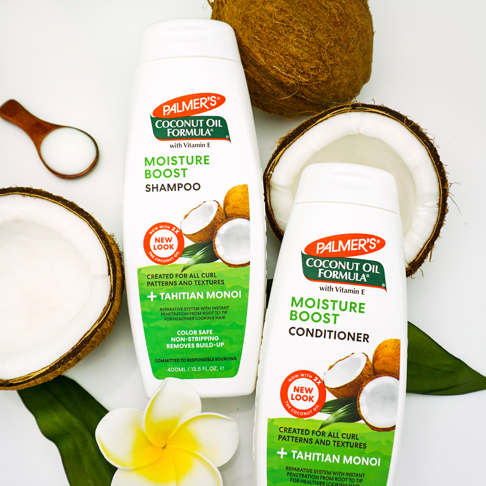 Palmer's Coconut Oil Formula Moisture Boost Shampoo and Conditioner for wavy hair on table with coconuts