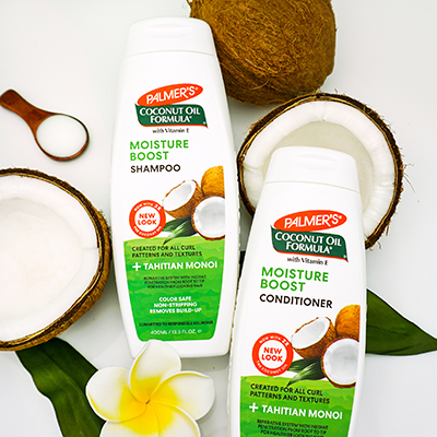 How to Keep Hair Moisturized in Summer with Palmer's Moisture Boost Shampoo and Conditioner on table with cracked open coconuts