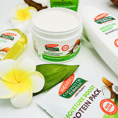 Palmer's Coconut Oil Formula Moisture Boost Deep Conditioner to moisturize protective styles on table with other products