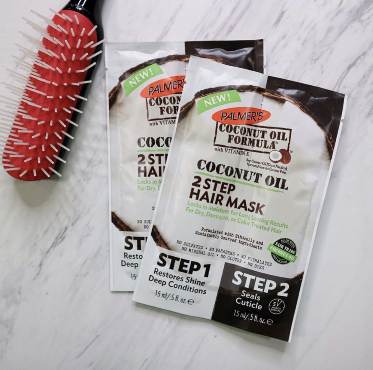 Palmer's Coconut Oil Formula 2 Step Hair Mask for dry hair on table with brush