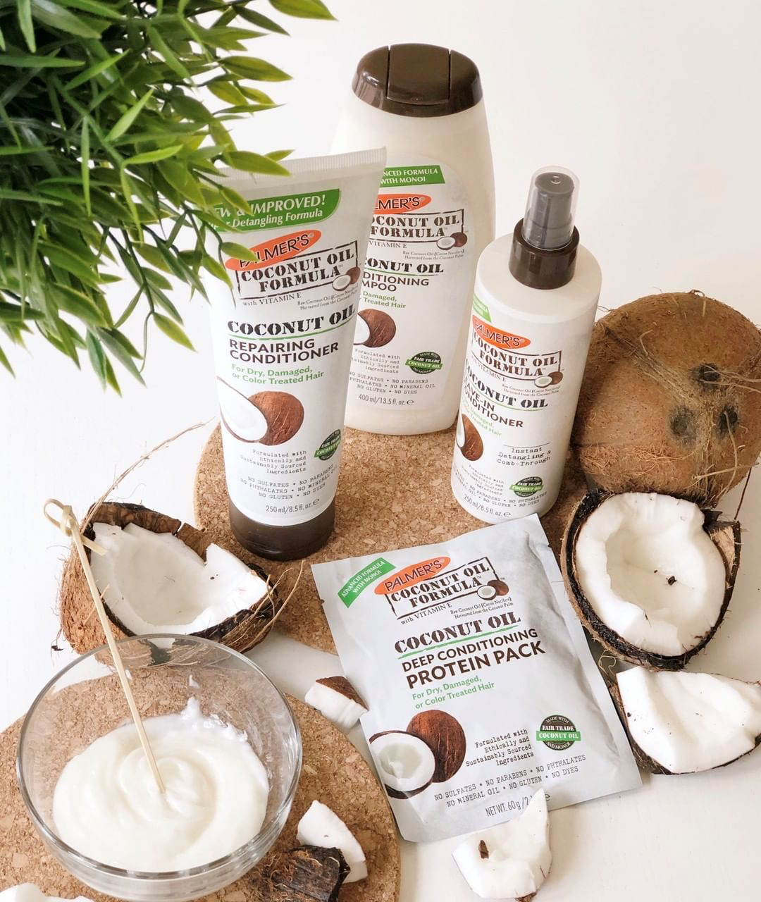 Palmer's Coconut Oil Formula Hair products for damaged hair on table with coconuts