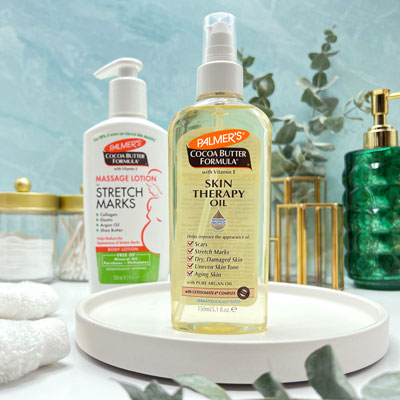 Palmer's Skin Therapy Oil, the best argan oil for stretch marks, on table with Massage Lotion
