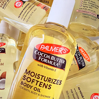 Palmer's Cocoa Butter Formula Moisturizing Body Oil, the best body oil for glowing skin, on table with other body oils
