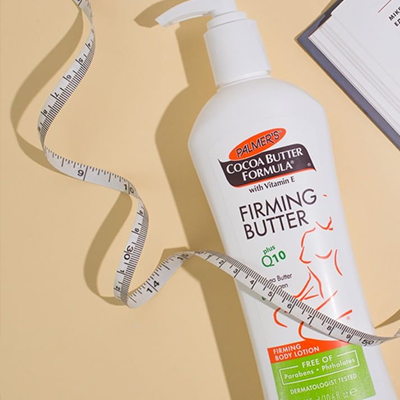 Palmer's Cocoa Butter Formula Firming Butter Lotion on table with tape measure and book