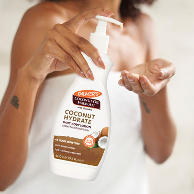 Woman applying Palmer's Coconut Hydrate Body Lotion, perfect for how to hydrate dry skin in the winter