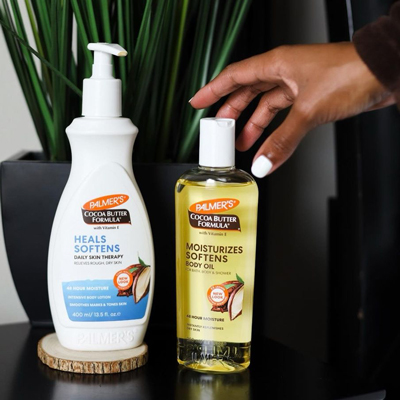 Woman's hand reaching for Palmer's Cocoa Butter products, the best way to heal dry skin