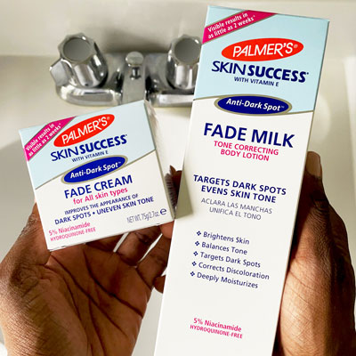 Hands holding the Skin Success Fade Milk and Fade Cream with niacinamide for acne scars