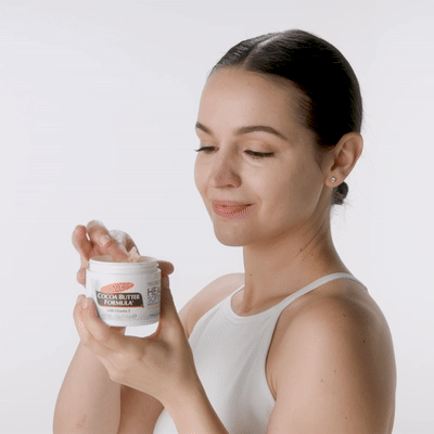 Woman applying Palmer's Cocoa Butter Formula Original Solid Jar to her face during skin slugging routine