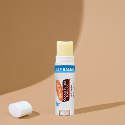 Palmer's Cocoa Butter Formula Lip Balm, a rich, moisturizing winter lip care product on a table with the cap off