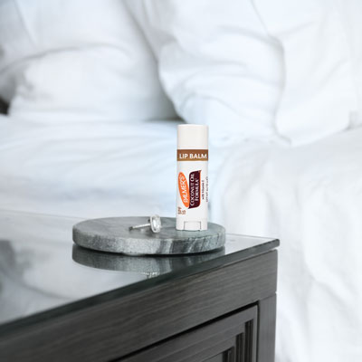 Palmer's Coconut Hydrate Lip Balm for winter lip care on nightstand in bedroom