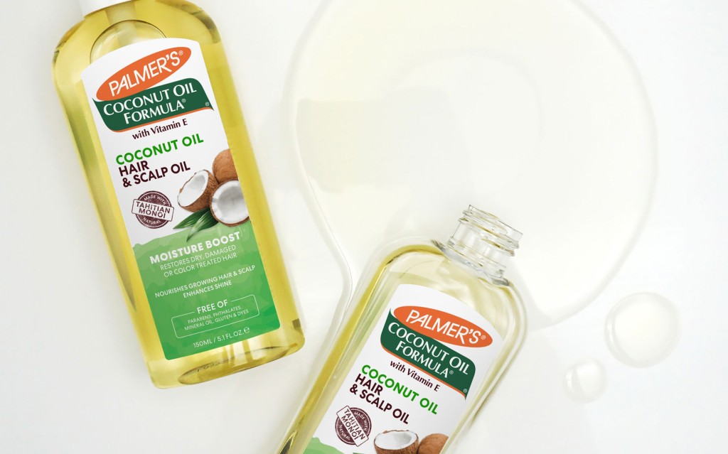 Palmer's Coconut Oil Hair & Scalp Oil bottles for hair slugging being spilled on table