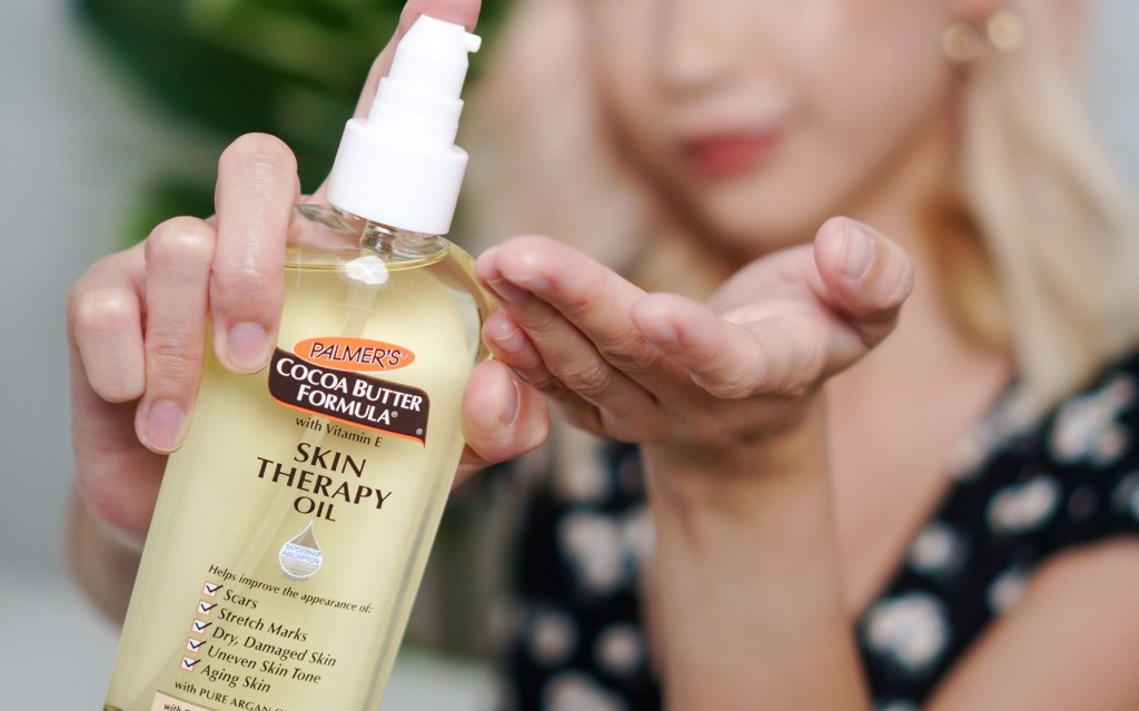Woman holding Skin Therapy Oil - the best product in how to improve the appearance of scars.