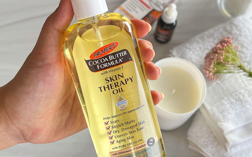 Palmer's Skin Therapy Oil, the best treatment for damaged skin, held in hand over vanity