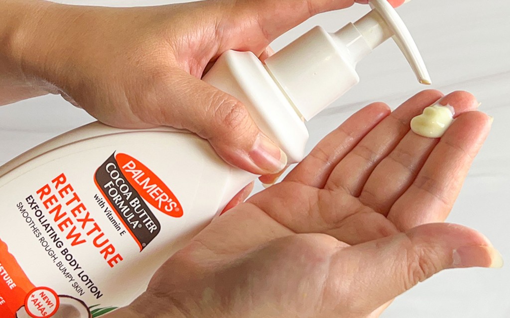 After learning what causes strawberry skin, woman applying Palmer's Retexture Renew Exfoliating Body Lotion into hand