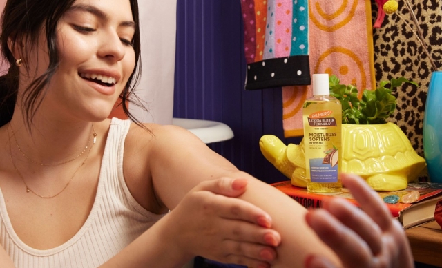 A woman applying Palmer's Cocoa Butter Formula Moisturizing Body Oil during her selfcare routine