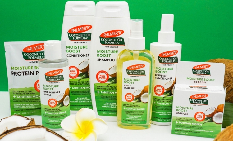 Palmer's Coconut Oil Formula Moisture Boost system, a coconut oil hair care routine for soft, healthy hair on a table with coconuts
