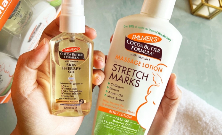 Woman's hands holding Palmer's Skin Therapy Oil and Massage Lotion, essentials for self care during the first trimester of pregnancy