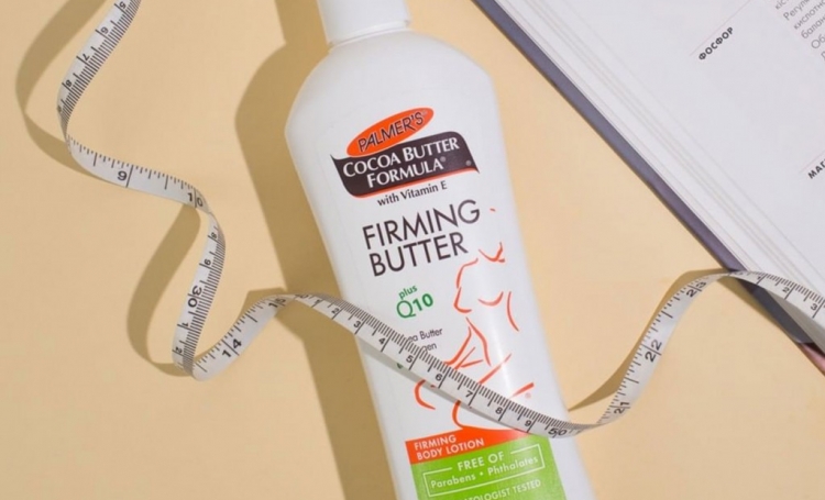 Palmer's Firming Butter, skin care for after pregnancy, on a table with a book and measuring tape