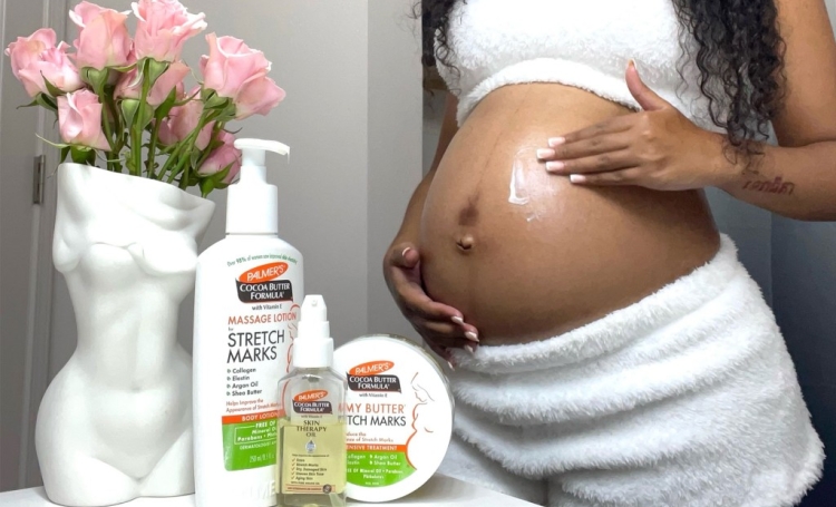 Black woman applying Palmer's Massage Lotion during her third trimester self care routine
